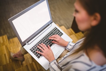 High angle view of businesswoman typing on laptop at office