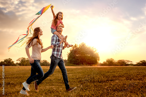 familie mit tochter rennt und lässt drachen steigen Poster