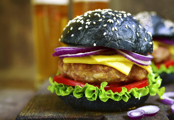 Black burger with meat cutlet on a cutting board.Rustic style.