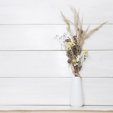 Autumn Still Life. Dried herbs in vase on white wooden backgroun
