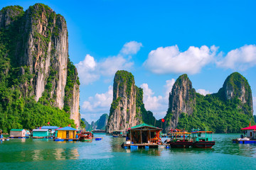 Wall Mural - Floating fishing village and rock island in Halong Bay, Vietnam, Southeast Asia. UNESCO World Heritage Site. Junk boat cruise to Ha Long Bay. Landscape. Popular landmark, famous destination of Vietnam