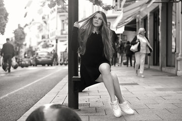 Wall Mural - Close-up Fashion woman black and white portrait of young pretty trendy caucasian girl posing at the city in Europe,summer street fashion with lovely sun backlight background