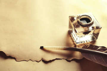 Wall Mural - Feather pen and inkwell on blank paper closeup