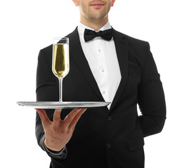 Canvas Print - Close up view of waiter holding tray with glass of champagne, on white background