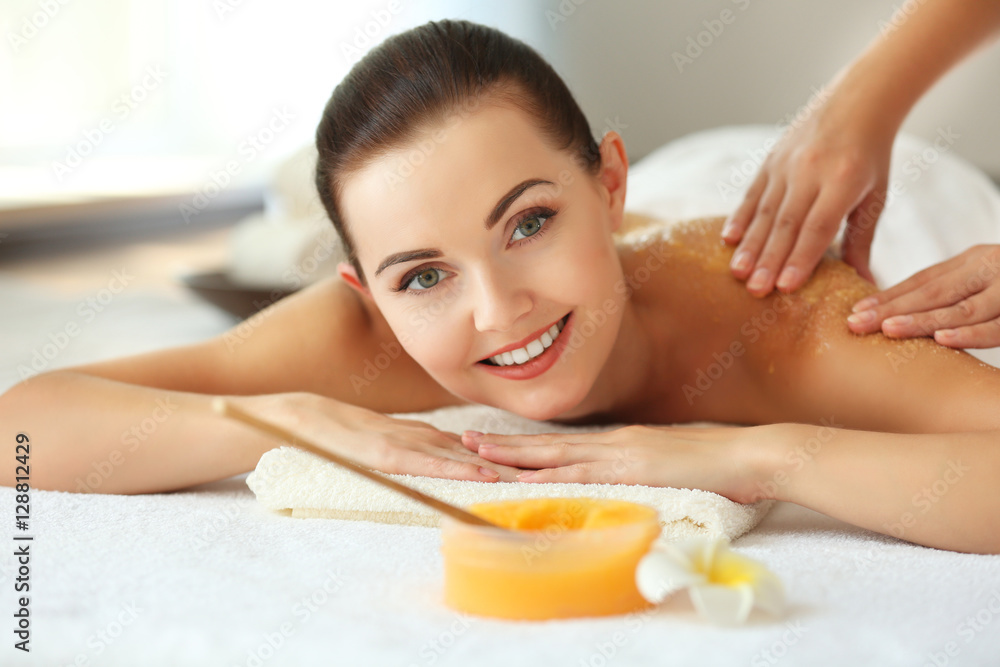 Spa concept. Hands massaging female back with scrub