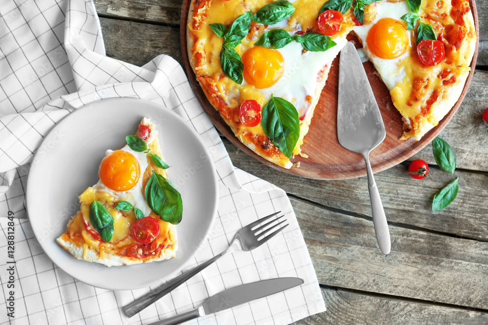 Margarita pizza with basil leaves and egg on wooden table, top view