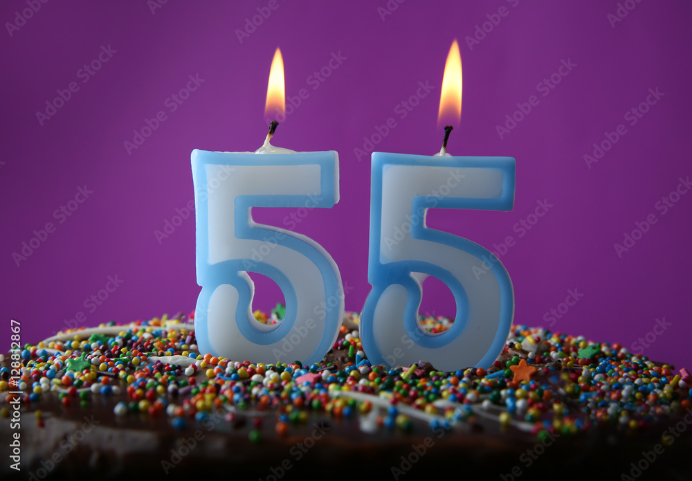 Birthday cake with burning candles on purple background