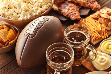 Table full of tasty snacks and beer prepared for watching rugby on TV