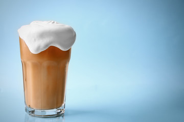 Sticker - Glass of iced coffee with cream on blue background