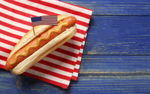 Hot Dog With Mustard And Small USA Flag On Napkin