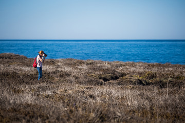 Wall Mural - Young lady with rucksack taking a picture