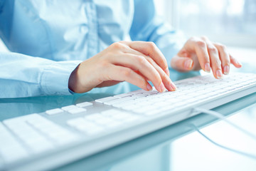 Woman office worker typing on the keyboard