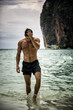 © theartofphoto - Half body shot of a handsome young man standing on a beach in Phuket Island, Thailand, shirtless wearing boxer shorts, showing muscular fit body