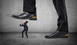 © gearstd - Tiny frightened businessman under feet of huge man