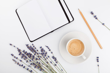 Wall Mural - Coffee, clean notebook and lavender flower on white  background from above. Woman working desk. Cozy breakfast. Mockup. Flat lay style.