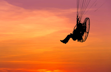 paraglider flying  with paramotor on sunset