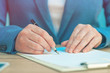 © Bits and Splits - Close up of female hands writing signature on business agreement
