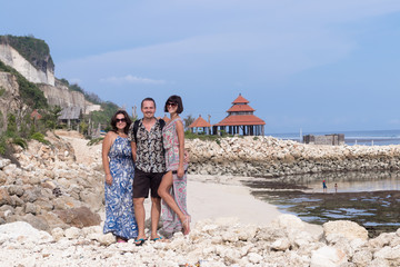 Two caucasian women in sunglasses and one man near the balinese temple. Explore Indonesia, Bali.