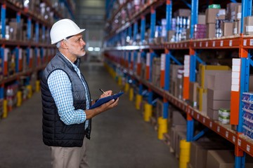 Serious manager working with a clipboard