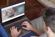 © GENETTICA - Top view of young man at home visiting healthcare videoblog on his laptop.