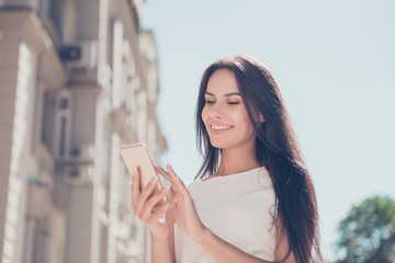 Poster - Smiling woman reading message on  mobile phone while standing on