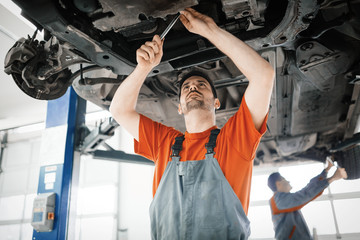 Wall Mural - Car mechanics working and maintaining car