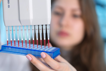 Sticker - Young woman in biological laboratory. Attractive young female scientis.Young scientist pipetting with multi pipette in genetic lab.