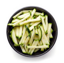 Wall Mural - Bowl of fresh zucchini slices isolated on white, from above