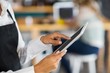 © WavebreakmediaMicro - Mid section of waitress using digital tablet