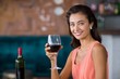 © WavebreakmediaMicro - Smiling woman holding glass of red wine