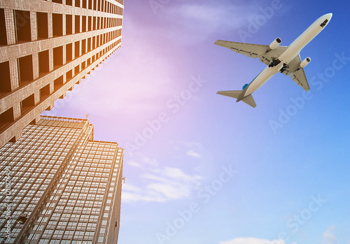 Modern tower with airplane flying over city Fototapet