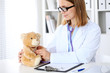 © rogerphoto - Female doctor examining a .Teddy bear  patient by stethoscope. Children medical care concept