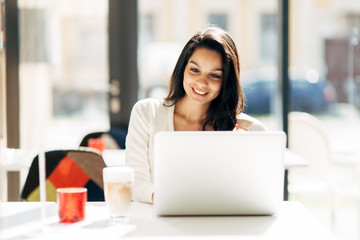 Brunette using laptop in cafe