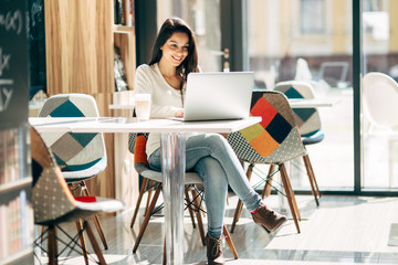 Brunette using laptop in cafe