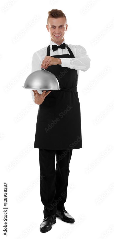 Handsome young waiter with cloche and tray on white background
