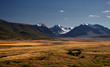 © nighttman - A highland river valley with yellow grass on a background of snow covered high mountains and glaciers under clouds and blue sky, Plateau Ukok, Altai Siberia, Russia