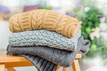 Wall Mural - Stack of white cozy knitted sweaters on a wooden table