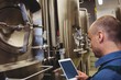 © WavebreakMediaMicro - Male manufacturer using digital tablet by machinery