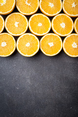 Poster - Fresh and juicy half cut oranges on dark stone table