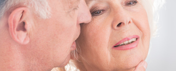 Wall Mural - Elderly man whispering to wife