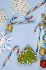 Gingerbread and candy canes on a blue wooden background. Christm