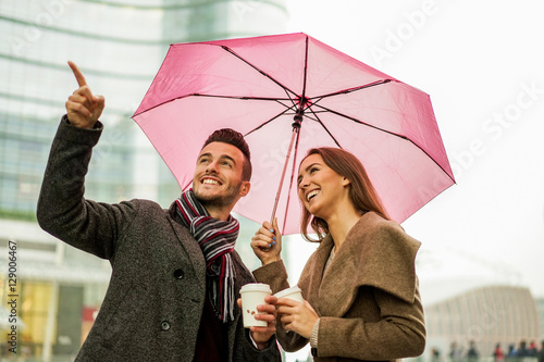 Plakat Szczęśliwa romantyczna para z kawą bierze oddaloną filiżankę pod parasolem