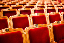 Sets On An Empty Theatre, Taken With Selective Focus And Shallow Depth Of Field. Empty Vintage Red Seats With Numbers, Teather Chair, Cinema Seats. Movie Theater Auditorium With Lines Of Red Chairs.