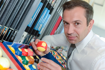 serious man prepares balls for start of game billiard