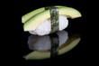 Sushi nigiri with avocado on black background with reflection. J