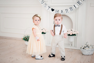 two babies wedding - boy and girl dressed as bride and groom