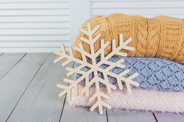 Wall Mural - Stack of white cozy knitted sweaters on a wooden table