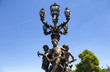 © theendup - Historical street lamp made with 3 children statues on Pont Alexandre III in Paris. Ornate, late 19th-century arched bridge in a Beaux Arts style & named after a Russian czar