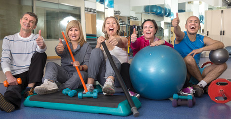 group of mature people posing with gymnastic facilities at the g