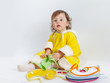 © azazello - Charming baby in yellow rompers chooses bib